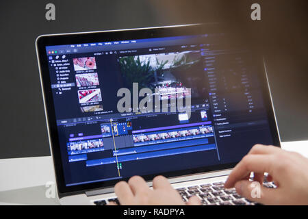 Editing di video con il computer portatile. Editor professionale aggiungendo effetti speciali o gradazione di colori le riprese per il film commerciali o filmato. L'uomo utilizzando software in com Foto Stock