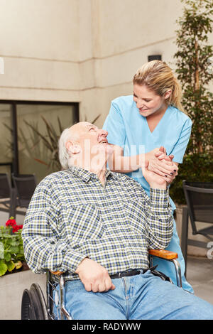 Infermiere cure del personale sanitario per senior uomo in sedia a rotelle alla clinica di riabilitazione Foto Stock