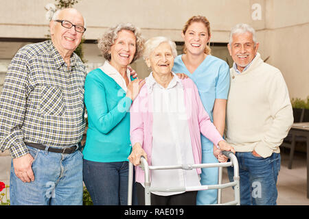 Gruppo di anziani come amici insieme con geriatrico infermiere in casa di cura Foto Stock