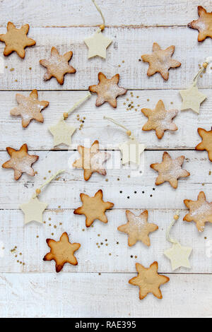 Piatto di laici forma a stella biscotti fatti in casa su un bianco sullo sfondo di legno Foto Stock