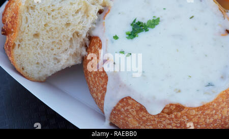 Close-up di clam chowder servita nel pane di pasta acida ciotola e guarnita con erbe aromatiche, una deliziosa Americana tradizionale cibo di strada, San Francisco, CA, Stati Uniti d'America Foto Stock