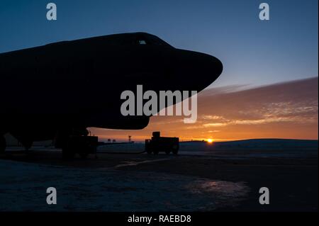 Il sole sorge alle spalle di una B-52H Stratofortress a Minot Air Force Base, N.D., Gennaio 26, 2017. Avieri dal 5 Manutenzione aeromobili squadrone lavorare intorno all'orologio in tutte le condizioni atmosferiche per fornire B-52 firepower on demand. Foto Stock