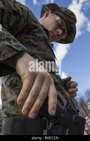 Stati Uniti Marine Corps Lance Cpl. Riley Thomas, studente, Marine Corps Embassy Security Group, classe 2-17, ripone la sua pistola durante il corso di formazione in gamma 1, Marine Corps base Quantico, Virginia, Jan 26, 2017. Le 8 settimane di corso prepara i Marines di efficace protezione internazionale ambasciate degli Stati Uniti e del personale, e include la formazione con la M9 pistola di servizio, M4 service fucile, e M870 fucile. Foto Stock