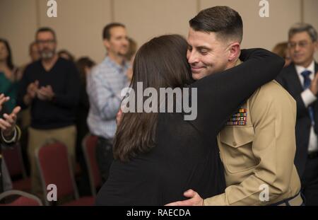 Stati Uniti Marine Corps Il Mag. Robert J. Crawford Jr., segretario personale per il comandante, Marine Corps installazioni Regione Capitol, abbracci la moglie durante il suo pensionamento cerimonia presso il Club a Quantico in Marine Corps base Quantico, Virginia, Gennaio 31, 2017. Crawford in pensione dopo 23 anni di onorato servizio militare. Foto Stock