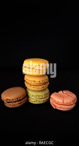In stile tradizionale francese amaretti, la selezione di diversi colori e sapori, molto luminosa bite-size dolciario, con un lampone macaron schiacciato Foto Stock