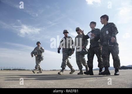 Stati Uniti Air Force aviatori assegnati alla contingenza 621st ala risposta di stanza a base comuneGuire-Dix Mc-Lakehurst, N.J., e Repubblica di Corea Air Force aviatori si riuniscono per ispezionare l'Aviosuperficie per determinare un piano di parcheggio per gli aeromobili in arrivo durante l'esercizio di distribuzione Turbo 17-3, in Pohang Air Base, Repubblica di Corea, 10 aprile 2017. Foto Stock