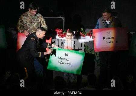 Stati Uniti Esercito il Mag. Bryan Ralls, il comandante e il conduttore per la ottantaduesima Airborne Division Band e Chorus, detiene un microfono a un pubblico stati cantando un paracadutista la versione del classico di vacanza, "12 giorni di Natale", presso il Crown Theatre di Fayetteville, North Carolina, Dic 13, 2018. La band ha suonato durante tutta la vacanza americana concerto per diffondere lo spirito natalizio a soldati, le famiglie e le comunità locali. Foto Stock