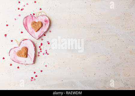 Il giorno di San Valentino con uno sfondo rosso due cuori squallido su sfondo chiaro. Vista dall'alto. Spazio per il testo. Foto Stock