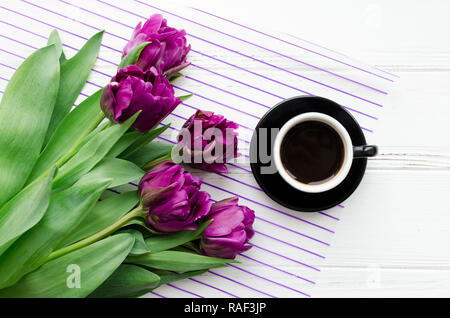 Tazza di caffè al mattino e bouquet di fiori di primavera tulipani bianco su sfondo di legno. Vista dall'alto. Mattina biglietto di auguri. Holiday, romanticismo della moderna l Foto Stock