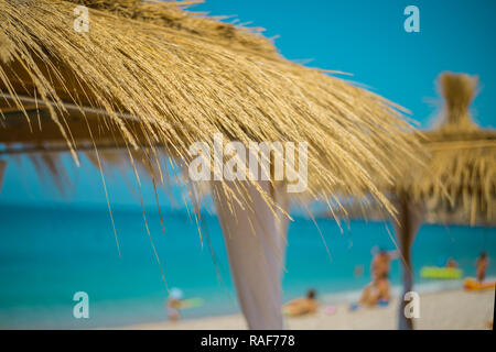 Ombrelloni e sdraio sulla spiaggia bellissima in Himara, Albania. Foto Stock