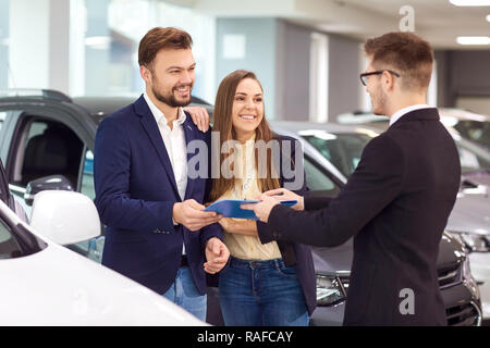 Vendita, noleggio auto. Un rivenditore di auto vende auto per i clienti. Foto Stock