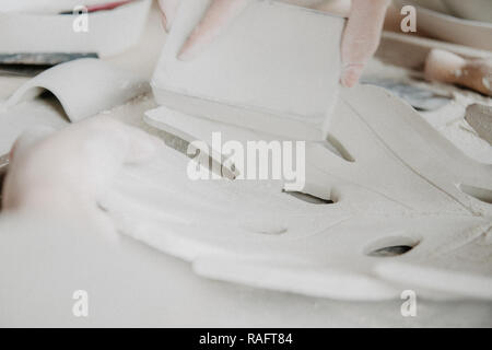 Donna fare ceramica. Vista dettagliata del processo di levigatura a piastra di argilla Foto Stock