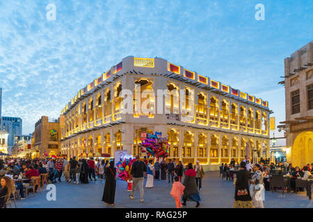 Vista serale della strada trafficata e il ristorante illuminato al Souq Waqif a Doha, in Qatar Foto Stock