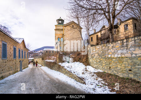 Vista di tradizionali edifici in pietra e strade con neve presso il famoso villaggio di Nymfaio vicino Florina, Grecia. Foto Stock