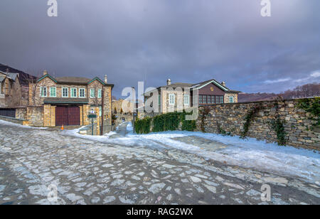 Vista di tradizionali edifici in pietra e strade con neve presso il famoso villaggio di Nymfaio vicino Florina, Grecia. Foto Stock