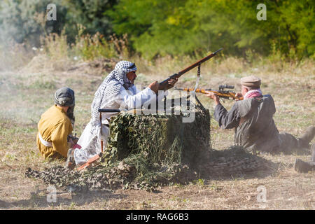 Festival storici Sambek altezze. Mujahideen sparare da dietro il coperchio Foto Stock