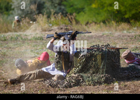 Festival storici Sambek altezze. Mujahideen sparare da dietro il coperchio Foto Stock