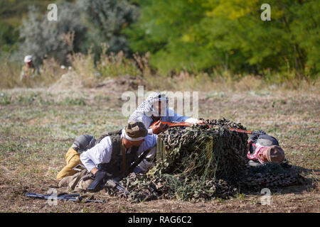 Festival storici Sambek altezze. Mujahideen sono seduti dietro le caselle verdi con armi Foto Stock