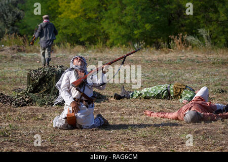 Festival storici Sambek altezze. Ucciso mojahed cade a terra con un fucile nelle sue mani Foto Stock