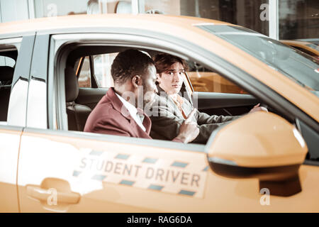 Inesperto giovane driver sensazione preoccupato seduto in macchina Foto Stock