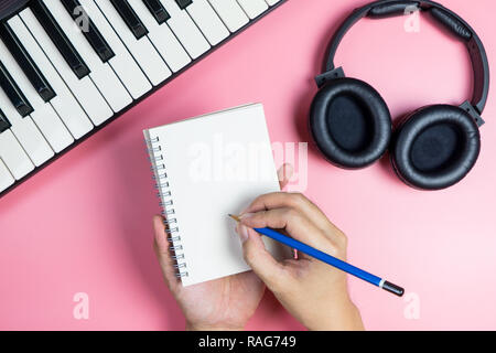 Il cantautore sta scrivendo la sua nuova musica su un notebook vuoto Foto Stock