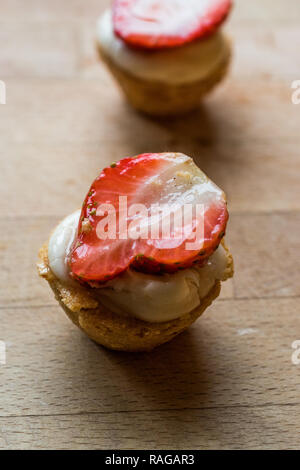 Mini crostate, Tartolet o pasticcini con Fragola, la crema di latte e frutta fresca. Concetto di dessert. Foto Stock