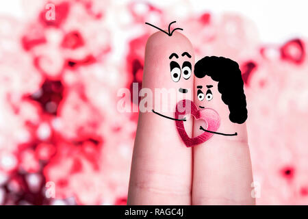 Dita con facce dipinte e i capelli con un cuore in mano, il concetto di amanti, vuota per il giorno di San Valentino Foto Stock