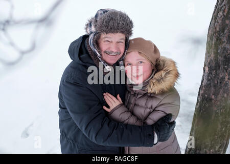 Ritratto di coppia di anziani avendo divertimento all'aperto nella foresta di inverno Foto Stock