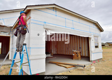 Casa in costruzione con builder installazione angolare di rinforzo per stucco su tavola di isolamento Foto Stock