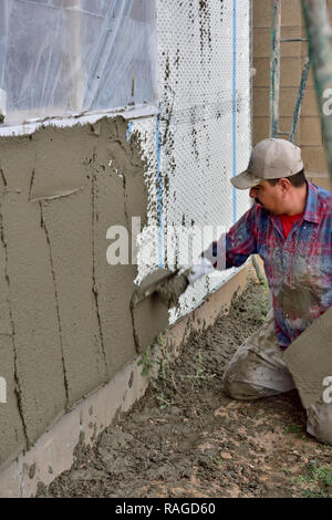 Nuova casa con struttura in legno in costruzione con stucco essendo applicato sopra il filo rinforzato con pannelli di isolamento da builder Foto Stock