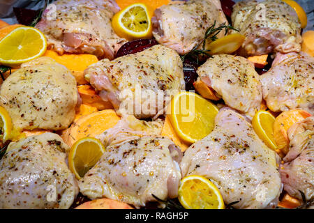 Materie piccante di cosce di pollo Cosce pronto per cuocere al forno con patate dolci, arance e rosmarino, vista dall'alto Foto Stock