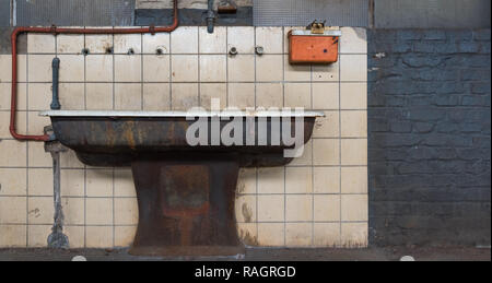 Il vecchio lavandino davanti alla parete piastrellata Foto Stock