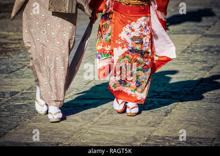 Due donne giapponesi in kimono a Piedi in Kamakura, Giappone con le loro ombre seguenti. Foto Stock