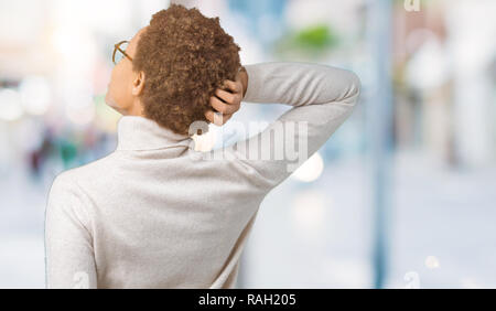 Giovani belle americano africano donna che indossa gli occhiali su sfondo isolato indietro pensando di dubbio con la mano sulla testa Foto Stock
