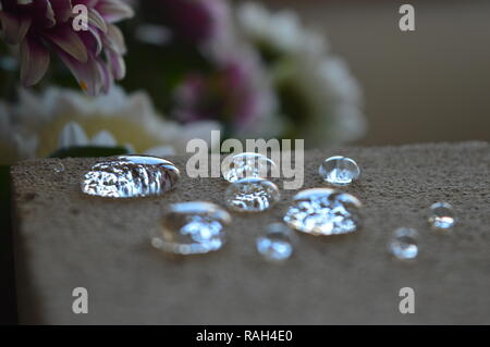 Minuscole goccioline di acqua su una superficie di cemento Foto Stock