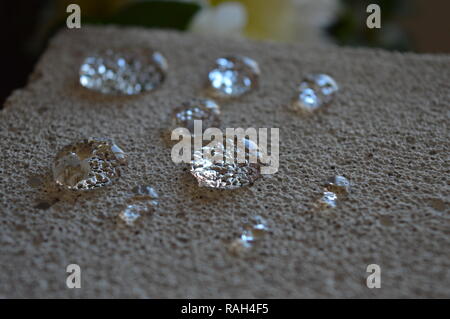 Minuscole goccioline di acqua su una superficie di cemento Foto Stock