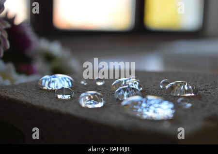 Minuscole goccioline di acqua su una superficie di cemento Foto Stock