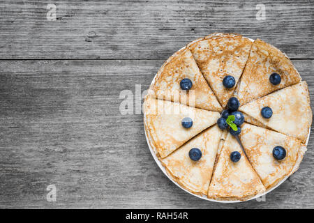 Laminati tradizionale russo o ucraino pancake con mirtilli freschi e menta per colazione. vista superiore con spazio di copia Foto Stock