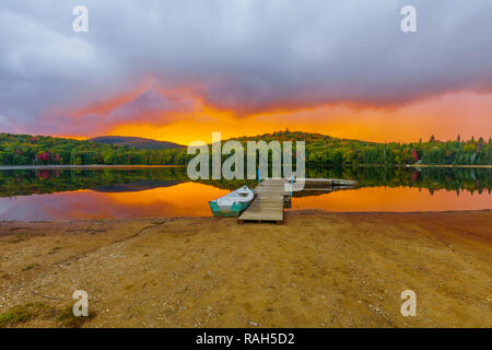 Barca e pier al tramonto in Petit Lac Monroe, Mont Tremblant NP, Quebec, Canada Foto Stock