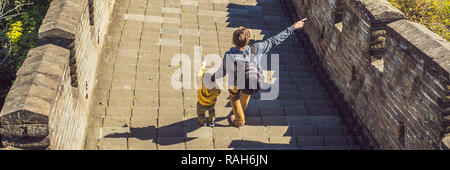 Felice allegro gioioso turisti papà e figlio presso la Grande Muraglia della Cina divertirsi sul viaggio sorridente ridendo e ballando durante il viaggio in Asia. Destinazione cinese. Viaggiare con i bambini in Cina concetto banner, formato lungo Foto Stock