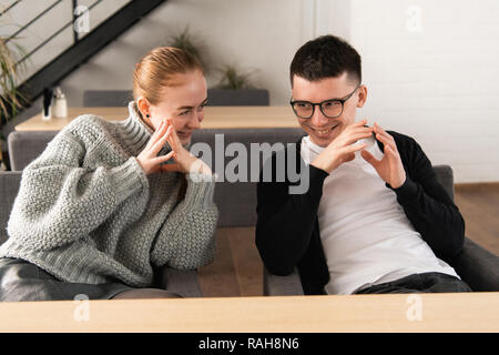 Closeup ritratto di zenzero le donne che raccontano i segreti per il suo collega. Dietro le quinte di collusione. Intrighi al lavoro Foto Stock