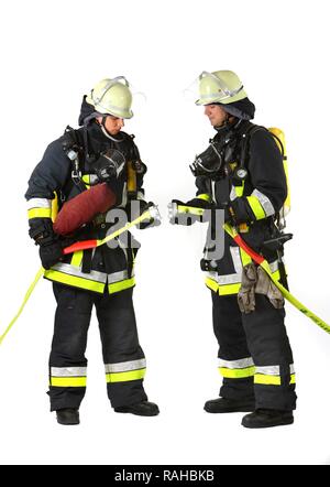 Vigili del fuoco da un sistema antincendio equipaggio indossando apparecchi respiratori di collegamento di due c-tubi flessibili, professional vigili del fuoco dal Foto Stock