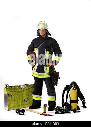 Vigile del fuoco, parte di una squadra di risposta per la lotta antincendio, con abbigliamento protettivo realizzato in Nomex, un casco con una visiera, un incendio ax, Foto Stock