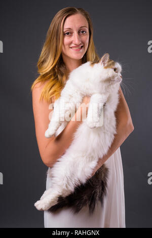 Giovane donna bellissima azienda simpatico gatto persiano Foto Stock
