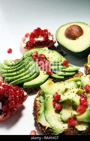 Tagliate a fette e avocado maturo melagrane per tostare il pane con spezie e avocado Foto Stock
