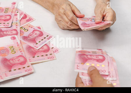 Cinese donna Senior conteggiare denaro per il pagamento Foto Stock
