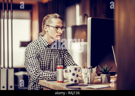 Attento persona di sesso maschile a fissare lo schermo del suo computer Foto Stock