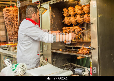 Istanbul, Turchia, febbraio 24, 2015: Chef polli di controllo la tostatura in una macchina rotissarie. Foto Stock