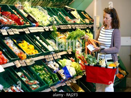 Donna shopping nel produrre la sezione self-service Foto Stock