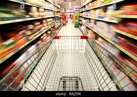 Svuota carrello essendo spinto attraverso un corridoio, sezione alimentare, supermercato Foto Stock